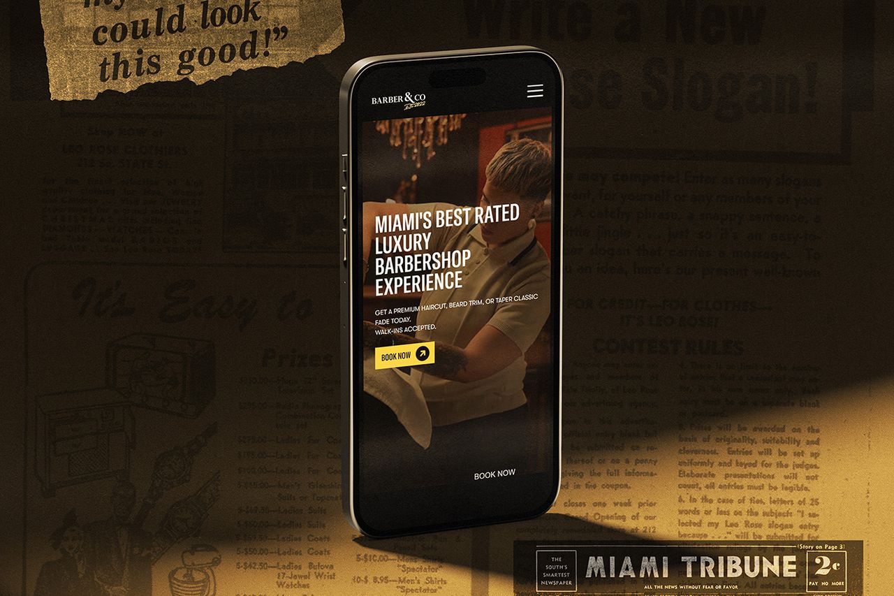 Phone showing the Barber & Co Miami homepage over a vintage newspaper advertisement